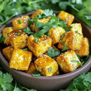 - 14 oz firm tofu, pressed and cubed - 2 tablespoons cornstarch - 1 tablespoon extra virgin olive oil - 3 tablespoons pure honey (or agave syrup for vegan) - 3 cloves garlic, minced - 2 tablespoons low-sodium soy sauce - 1 tablespoon rice vinegar - 1 teaspoon sesame oil - 1/4 teaspoon red pepper flakes (optional) - Fresh cilantro leaves, chopped - Toasted sesame seeds To make the Air Fryer Crispy Honey Garlic Tofu Bites, you need simple ingredients. The main ingredient is firm tofu. You want the tofu to be pressed and cubed. This helps it get crispy. Cornstarch is key for a crunchy outside. Extra virgin olive oil adds richness and helps the cornstarch stick. Honey gives sweetness. If you want a vegan option, use agave syrup instead. For flavor, garlic is a must. Minced garlic gives great taste. Low-sodium soy sauce adds saltiness. Rice vinegar brings a bit of tang. Sesame oil adds depth. If you like heat, add red pepper flakes. For garnishing, fresh cilantro adds color and flavor. Toasted sesame seeds give a nice crunch. All these ingredients work together to create tasty tofu bites. They are perfect for snacking or as part of a meal. To start, we need to press the tofu. This step is key to get rid of extra moisture. You can use a tofu press or wrap the tofu in a clean towel. Place a heavy object on top for about 20-30 minutes. Once it’s pressed, cut the tofu into bite-sized cubes, about 1 inch each. In a large bowl, add the pressed tofu cubes. Drizzle 1 tablespoon of extra virgin olive oil over the tofu. Gently toss the cubes to coat them evenly with the oil. Next, sprinkle 2 tablespoons of cornstarch over the tofu. Toss again to make sure every piece is covered. This will help the tofu turn crispy when it cooks. Now, let’s preheat the air fryer. Set it to 375°F (190°C) and let it run for about 5 minutes. Once it’s hot, arrange the tofu cubes in a single layer in the air fryer basket. Make sure to leave some space between the cubes for air to flow. If needed, cook them in batches. While the tofu is air frying, we can make the honey garlic sauce. In a small saucepan, mix together 3 tablespoons of honey, 3 cloves of minced garlic, 2 tablespoons of low-sodium soy sauce, 1 tablespoon of rice vinegar, and 1 teaspoon of sesame oil. If you like some heat, add 1/4 teaspoon of red pepper flakes. Stir the mixture over medium heat until it simmers and thickens, about 3-5 minutes. Once the tofu is crispy and golden, transfer it to a large bowl. Pour the honey garlic sauce over the tofu and gently toss it until each piece is well coated and shiny. For serving, consider garnishing with fresh chopped cilantro and toasted sesame seeds. This adds extra flavor and a nice crunch. Enjoy your crispy honey garlic tofu bites! To get the best crispiness, start by coating the tofu evenly with cornstarch. This coating is key. It helps the tofu become golden and crunchy. Use about 2 tablespoons of cornstarch for 14 oz of tofu. Toss the cubes gently so they are well coated. Next, preheat your air fryer to 375°F (190°C). This step is important. It ensures the tofu cooks evenly. Cook the tofu for 15-20 minutes. Be sure to shake the basket halfway through. This helps all sides get crispy. Want to add some heat? Increase the red pepper flakes in the sauce. Adding more will give your bites a nice kick. If you prefer a sweeter taste, swap out honey for agave syrup. This change is perfect for a vegan option. Both sweeteners blend well with the garlic in the sauce. The balance of sweet and spicy creates a tasty bite. Presentation matters! Serve your crispy tofu bites on a bed of fresh greens. You can also use jasmine rice as a base. This adds color and flavor to the dish. For fun, use chopsticks or skewers to serve. They make eating more enjoyable. Garnish with fresh cilantro and toasted sesame seeds. This adds a nice crunch and a pop of color. Enjoy your beautiful and tasty dish! {{image_4}} You can switch up the flavor by replacing honey with maple syrup. Maple syrup gives the tofu a unique taste. It also keeps the dish sweet without using honey. Another fun option is to try different sauces. You can use teriyaki or sweet and sour sauce instead of the honey garlic sauce. Each sauce brings its own twist, making the dish exciting. If you want to make the dish vegan, you can use agave syrup instead of honey. Agave syrup is a great sweetener that works well in this recipe. For those who need gluten-free options, tamari can replace soy sauce. Tamari gives the same great flavor without gluten. To make this dish more colorful, add vegetables like bell peppers or broccoli. These veggies not only add color but also boost nutrition. You can create a tasty stir-fry by mixing tofu with these veggies. This adds more texture and flavor to your meal. Cooking tofu and veggies together makes a complete dish that everyone will love. To store your crispy honey garlic tofu bites, use an airtight container. Glass containers work great for this. You can keep them in the fridge for up to four days. This way, you can enjoy leftovers without worry. To reheat tofu bites, the air fryer is the best option. Preheat it to 350°F (175°C). Place the tofu in the basket for about 5 to 7 minutes. This keeps them crispy. You can also use a skillet over medium heat. Just add a little oil to keep them crunchy. You can freeze the tofu bites for later meals. Place them in a single layer on a baking sheet. Freeze them for about an hour, then transfer to a freezer bag. They’ll last about three months in the freezer. When ready to eat, thaw them in the fridge overnight. Reheat as mentioned above for the best results. Enjoy your tasty bites anytime! Using soft tofu changes the dish. Soft tofu is delicate and won't hold shape. Firm tofu stands up well during cooking. It gives a nice crispy bite. For this recipe, always pick firm tofu for the best results. To add more heat, use red pepper flakes. You can double the amount for extra spice. Another option is to add sriracha sauce to the honey garlic sauce. Mix in a teaspoon for a nice kick. Adjust based on your taste. Pressing tofu is simple and important. Use a tofu press if you have one. If not, wrap the tofu in a clean towel. Place a heavy object on top, like a cast iron skillet. Let it sit for 20-30 minutes to remove moisture. Yes, you can use the honey garlic sauce as a marinade. Coat the tofu in the sauce before cooking. Let it marinate for at least 30 minutes. This adds flavor throughout the tofu. Remember to reserve some sauce for later! This blog post covered how to make crispy tofu with a sweet and savory honey garlic sauce. You learned about the key ingredients like firm tofu, cornstarch, and flavor components such as garlic and soy sauce. I shared step-by-step instructions for preparation, cooking, and finishing touches. You also found tips for perfecting the tofu’s crispiness and creative serving ideas. Tofu is flexible and tasty, making it a great dish for everyone. Enjoy experimenting with variations to find your favorite twist!