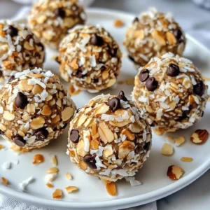 - 1 cup rolled oats - 1 cup shredded unsweetened coconut - 1/2 cup creamy almond butter - 1/4 cup natural honey or maple syrup - 1/4 cup dark chocolate chips - 1/4 cup chopped almonds - 1 teaspoon pure vanilla extract - Pinch of flaky sea salt - Prep Time: 15 minutes - Total Time: 45 minutes - Servings: 12-15 To make these energy balls, gather your ingredients first. You want to have everything ready. The rolled oats and shredded coconut form the base. They give great texture. The creamy almond butter adds a rich taste and binds it all together. You can use honey or maple syrup for sweetness. Dark chocolate chips add a nice touch of indulgence. Chopped almonds give a nice crunch. Next, let's talk about prep time. It takes 15 minutes to get everything mixed. The total time, including chilling, is 45 minutes. You can make about 12 to 15 balls, depending on how big you want them. Remember, these energy balls are not just easy to make; they are also fun! You can enjoy them as a snack at any time. {{ingredient_image_2}} In a large mixing bowl, combine 1 cup of rolled oats with 1 cup of shredded coconut. Stir well to mix them evenly. This step sets a great base for your energy balls. In another bowl, whisk together 1/2 cup of creamy almond butter, 1/4 cup of natural honey or maple syrup, 1 teaspoon of pure vanilla extract, and a pinch of flaky sea salt. Mix until the mixture is smooth and creamy. This will bring sweetness and flavor to your energy balls. Pour the wet mixture over the dry mixture. Add in 1/4 cup of dark chocolate chips and 1/4 cup of chopped almonds. Mix everything together until the mixture feels sticky and cohesive. This texture helps the energy balls hold together. Scoop out tablespoon-sized portions of the mixture and roll them into balls. Aim for about 12 to 15 energy balls, depending on your size choice. Place the rolled balls on a parchment-lined baking sheet. This keeps them from sticking. Refrigerate your energy balls for at least 30 minutes. Chilling helps them set and firm up nicely. This step makes your snack easy to grab and enjoy later. You can change the Almond Joy Energy Balls to fit your diet. For a vegan option, use maple syrup instead of honey and choose dairy-free chocolate chips. This keeps the sweet taste while making it plant-based. If you need a gluten-free option, make sure your oats are labeled gluten-free. This small change helps you enjoy the snack without worry. To keep your Almond Joy Energy Balls fresh, store them in an airtight container. You can use a glass jar or a plastic food storage container. These balls stay good for about one week in the fridge. If you want to keep them longer, you can freeze them. They can last for up to three months in the freezer. Just let them thaw in the fridge before eating. Each Almond Joy Energy Ball has about 100 calories. They contain 3 grams of protein, 5 grams of fat, and 10 grams of carbohydrates. The key ingredients offer health benefits too. Almonds give you healthy fats and protein. Coconut adds fiber and helps with digestion. Dark chocolate has antioxidants, which are good for your heart. So, these snacks not only taste great but also provide good nutrition. Pro Tips Use Fresh Ingredients: Always opt for fresh, high-quality almond butter and dark chocolate chips to enhance the flavor of your energy balls. Adjust Sweetness: Feel free to adjust the amount of honey or maple syrup based on your preference for sweetness. Experiment with Mix-ins: Try adding different nuts, seeds, or dried fruits to customize your energy balls to your liking. Storage Tips: Store the energy balls in an airtight container in the refrigerator for up to a week or freeze for longer shelf life. {{image_4}} You can make your Almond Joy Energy Balls look great. Serve them in a clear glass jar. This way, everyone can see the tasty snacks inside. You can also arrange them on a nice platter. For extra flair, sprinkle shredded coconut on top of each ball. This adds a fun touch and makes them look even more appealing. Pair these energy balls with a cool drink. A glass of almond milk works well. You can also enjoy them with hot tea or coffee. If you're feeling adventurous, try them with fresh fruit like bananas or apples. These pairings make a great snack or quick breakfast! You can switch things up with different flavors. Try making a mint chocolate version. Just add a little peppermint extract to the mix. It gives a fresh taste that pairs well with chocolate. If you like peanut butter, swap almond butter for it. This gives the energy balls a rich, nutty flavor. Not a fan of almond butter? You can use cashew butter instead. It has a creamy texture and sweet taste. For a sweetener, honey works great, but maple syrup is a good choice too. Both options add natural sweetness without extra fuss. Change the flavors with the seasons. In fall, mix in some pumpkin spice. It adds warmth and coziness, perfect for chilly days. You can also add dried fruits like mango or pineapple for a tropical twist. This keeps the energy balls fun and fresh all year long. Yes, you can freeze Almond Joy Energy Balls. To freeze them, place the balls in a single layer on a baking sheet. Once frozen, transfer them to a freezer bag or airtight container. This method keeps them fresh and prevents sticking. For thawing, simply take out the number you want and leave them in the fridge overnight. They will be ready to eat the next day. Almond Joy Energy Balls last about a week in the fridge. Store them in an airtight container to keep them fresh. If you freeze them, they can last up to three months. Always check for any signs of spoilage, like a strange smell or texture, before eating. Yes, using a food processor makes this recipe easier. It can quickly mix the oats, coconut, and other ingredients. This saves time and helps achieve a smooth texture. Just pulse the dry ingredients first, then add the wet ones for a cohesive mixture. It&rsquo;s a great tool for busy cooks. You can find gluten-free oats at most grocery stores. Check the health food aisle or the gluten-free section. Many brands label their oats as gluten-free. You can also look online for specialty stores that offer these oats. Always read the labels to ensure they meet your needs. Almond Joy Energy Balls are easy to make and full of flavor. With simple steps, you can whip up a tasty snack in no time. From the mix of oats, coconut, and almond butter, to the sweet touch of honey and chocolate, these treats shine. Remember to try the variations! You can even switch up the flavors or add some seasonal ingredients. Enjoy them as a quick snack or a fun dessert. These energy balls are sure to be a hit! Now, grab your ingredients and get started!