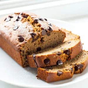 To make this tasty fall delight, you need the following main ingredients: - 1 cup canned pumpkin puree - 1/2 cup vegetable oil - 1 cup brown sugar, packed tightly - 1/2 cup granulated sugar - 3 large eggs, at room temperature - 1 teaspoon pure vanilla extract - 2 cups all-purpose flour - 1 teaspoon baking soda - 1/2 teaspoon baking powder - 1 teaspoon ground cinnamon - 1/2 teaspoon ground nutmeg - 1/2 teaspoon salt - 1 cup semi-sweet chocolate chips These ingredients blend to create a moist and flavorful bread. The pumpkin puree adds moisture and flavor, while the sugars give it sweetness. The spices bring warmth and a fall vibe. You can add extra flavor with optional ingredients: - 1/2 cup walnuts or pecans, chopped Adding nuts gives a nice crunch and extra taste. You can also top the bread after baking. A light dusting of powdered sugar or a dollop of cream cheese frosting makes it even better. If you want to change things up, here are some substitutions: - Use coconut oil instead of vegetable oil for a different flavor. - Swap granulated sugar for coconut sugar for a healthier option. - If you need a gluten-free option, use a gluten-free flour blend. These swaps can help cater to dietary needs while keeping the bread delicious. Remember, baking is all about having fun and trying new things! {{ingredient_image_2}} First, set your oven to 350&deg;F (175&deg;C). This temperature is key for baking. Next, take a 9x5-inch loaf pan. Grease it with non-stick spray. You can also line it with parchment paper. This helps the bread come out easily after baking. In a large bowl, combine 1 cup of canned pumpkin puree and 1/2 cup of vegetable oil. Add 1 cup of packed brown sugar and 1/2 cup of granulated sugar. Whisk everything until it is smooth. This step helps blend the sugars with the pumpkin. Next, crack in 3 large eggs. Add 1 teaspoon of pure vanilla extract. Whisk again until the mix looks creamy and well combined. In another bowl, sift together 2 cups of all-purpose flour, 1 teaspoon of baking soda, 1/2 teaspoon of baking powder, 1 teaspoon of ground cinnamon, 1/2 teaspoon of ground nutmeg, and 1/2 teaspoon of salt. This ensures no lumps in your dry mix. Now, gradually add this dry mix to the wet ingredients. Use a spatula to fold gently. Mix just until you don&rsquo;t see any flour. Be careful not to overmix, as that can make your bread tough. Now, fold in 1 cup of semi-sweet chocolate chips. If you like, you can add 1/2 cup of chopped walnuts or pecans. Pour the batter into your prepared loaf pan. Smooth the top with a spatula for even baking. Place the pan in the oven. Bake for about 55-65 minutes. To check if it&rsquo;s done, insert a toothpick into the center. It should come out clean or with a few moist crumbs. Once baked, remove the bread from the oven. Let it cool in the pan for about 10 minutes. After that, move it to a wire rack to cool completely. To get the best texture in your chocolate chip pumpkin bread, use room temperature eggs. This helps the batter mix better. Also, avoid overmixing when combining wet and dry ingredients. Mix just until there are no flour streaks. Overmixing can make the bread tough. Letting the batter rest for a few minutes before baking can help too. I recommend using semi-sweet chocolate chips for a balanced flavor. They melt nicely and add sweetness without being too rich. You can also try dark chocolate chips for a deeper taste. If you want a fun twist, use peanut butter chips or butterscotch chips. They pair well with pumpkin flavor. One mistake is not measuring ingredients correctly. Use measuring cups and spoons for accuracy. Another mistake is baking at the wrong temperature. Always preheat your oven to 350&deg;F (175&deg;C) before putting in the bread. Check your bread with a toothpick to avoid underbaking. Lastly, don&rsquo;t skip the cooling step. Letting the bread cool for ten minutes helps it set and makes slicing easier. Pro Tips Check Your Pumpkin: Make sure to use pure pumpkin puree and not pumpkin pie filling, as the latter contains added sugars and spices that can alter the flavor of your bread. Room Temperature Eggs: Using eggs at room temperature helps them incorporate better into the batter, resulting in a smoother texture and better rise. Don&rsquo;t Overmix: When combining wet and dry ingredients, mix just until you don&rsquo;t see any dry flour. Overmixing can lead to a dense and tough bread. Cool Before Slicing: Allow the bread to cool completely on a wire rack before slicing to prevent it from becoming gummy or falling apart. {{image_4}} You can make this pumpkin bread gluten-free. Use a gluten-free flour blend. Look for one that works well in baking. This blend should replace all-purpose flour in a 1:1 ratio. Make sure to check the label to ensure it contains xanthan gum. This helps give the bread the right texture. If you want a dairy-free option, swap the vegetable oil for melted coconut oil. You can also use almond milk instead of eggs. Use 1/4 cup of unsweetened applesauce for each egg. This keeps the bread moist and fluffy. You can spice up your bread with different flavors. Try adding 1/2 teaspoon of ginger or allspice for a warm taste. You can also mix in 1/2 cup of dried cranberries or raisins for added sweetness. Chopped apples or pears can add extra moisture and flavor too. Don't forget to experiment with nuts like pecans or walnuts for a crunchy bite. You can store your chocolate chip pumpkin bread easily. First, let it cool completely. Wrap it tightly in plastic wrap. This keeps it moist and fresh. You can also place it in an airtight container. Store it at room temperature for up to three days. If you want to keep it longer, the fridge is a good option. Just remember, this may change the texture a bit. Freezing chocolate chip pumpkin bread is simple. After cooling, slice the bread into pieces. Wrap each slice in plastic wrap. Then place all the wrapped slices in a freezer bag. Make sure to remove as much air as possible. This helps prevent freezer burn. You can freeze it for up to three months. When ready to eat, just thaw it in the fridge overnight. Chocolate chip pumpkin bread lasts well when stored properly. At room temperature, it lasts about three days. In the fridge, it can last up to a week. If you freeze it, it stays good for three months. Always check for any signs of spoilage, like mold or an off smell. Enjoy your tasty bread while it&rsquo;s fresh! Yes, you can use fresh pumpkin. First, cook the pumpkin until soft. Then, mash it well. You need one cup of fresh pumpkin puree. This can add a nice flavor. Just make sure it's smooth, like the canned version. To check if the bread is done, use a toothpick. Insert it into the center of the loaf. If it comes out clean or has a few moist crumbs, the bread is ready. The top should also look golden brown. Trust your senses; the smell is a good clue too! Yes, you can make this bread ahead of time. Bake it and let it cool completely. Then, wrap it well in plastic wrap. Store it at room temperature for up to three days. It also freezes well for up to three months. Just thaw it when you're ready to enjoy! You now have a clear path to making chocolate chip pumpkin bread. We covered key ingredients, step-by-step instructions, and useful tips. I shared how to store your bread for freshness and answered common questions. Remember, baking is about having fun. Don't be afraid to try new flavors or tweaks! Enjoy this tasty treat with family and friends. Your perfect chocolate chip pumpkin bread awaits, so get baking!